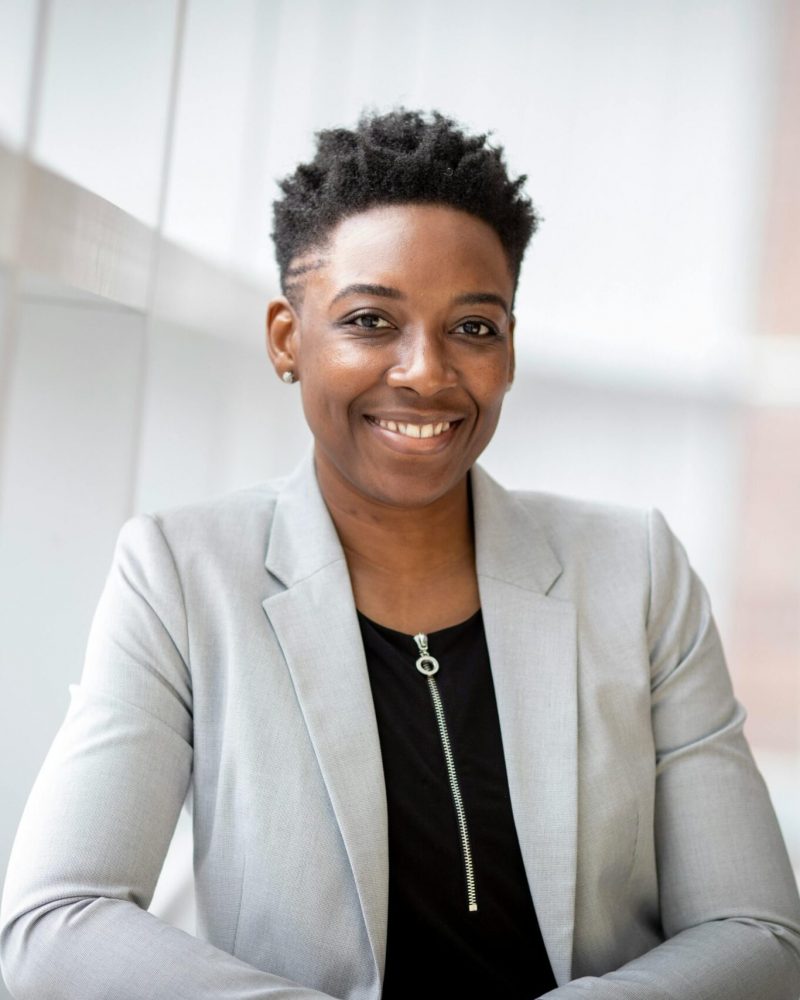 pexels-photo-2381069-2381069 Confident African American businesswoman smiling inside a modern office space.